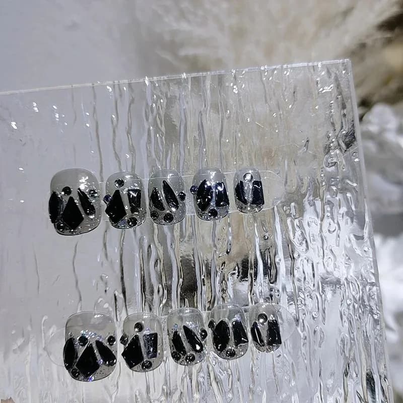 Korte genanvendelige press-on negle med sort diamantdesign