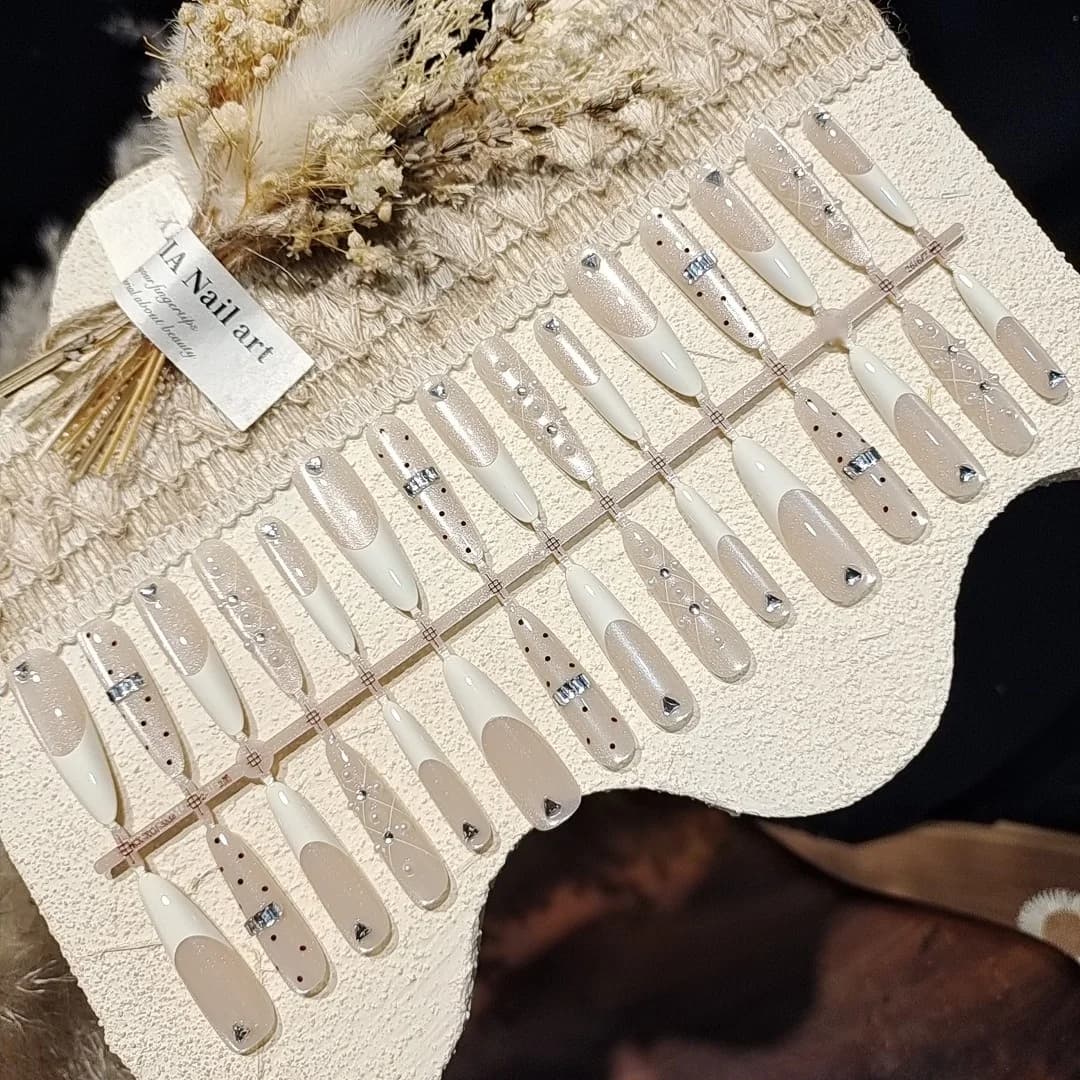 Mælkehvide tryk-på negle med store rhinsten, Cat Eye-effekt